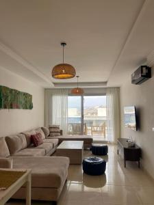 a living room with a couch and a table at Beach & Pool - Adan Beach in Aourir