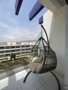 a swinging chair on a balcony with a view at Beach & Pool - Adan Beach in Aourir