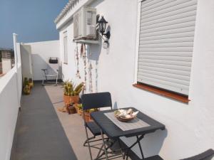 a small table and chairs on a balcony at L'àtic dels flamencs in Sant Jaume d'Enveja