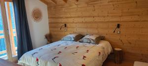 a bedroom with a bed with a wooden wall at Chalet recent , 5 min télésiège de la Roche, virage 12 in La Plagne Tarentaise