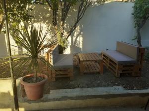 un patio con panchina, tavolo e piante di Summer with family friends in Tigzirt Garden & Terrace a Tigzirt