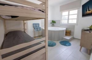 ein Schlafzimmer mit einem Etagenbett und einer Badewanne in der Unterkunft Vila Granot - Boutique Villa in the Galilee in Shelomi + 6 Fotos