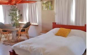 ein Schlafzimmer mit einem Bett und einem Tisch und Stühlen in der Unterkunft Vila Granot - Boutique Villa in the Galilee in Shelomi