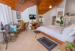 ein Schlafzimmer mit einem Bett und einem Tisch und Stühlen in der Unterkunft Vila Granot - Boutique Villa in the Galilee in Shelomi