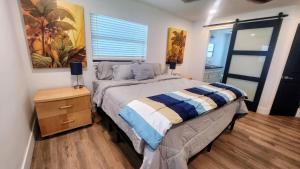 フォートマイヤーズビーチにある1 Block To Beach - Fully Upgraded Spacious & Quietのベッドと壁に絵が飾られた寝室