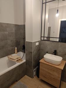 a bathroom with a tub and a sink and a bath tub at Apartament na Letniej in Kłodzko +14 photos
