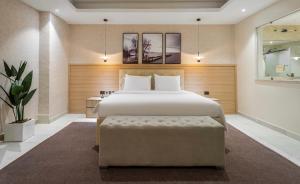 a bedroom with a large bed with a bench in it at Charles Fancy in Ilado +15 photos