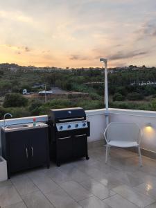 a grill and a chair on a balcony at Drea Acitrezza Luxury Home in Acitrezza