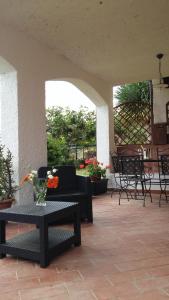 a patio with a table with a vase of flowers on it at Villa Eleanto in Cefalù
