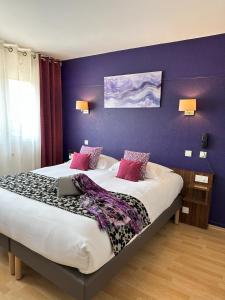 Hôtel Brun في Saint-Lattier: غرفة نوم بها سرير عليه جهاز كمبيوتر محمول