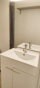 a bathroom with a white sink and a mirror at Studio Colibri 2 à 4 personnes in La Mongie