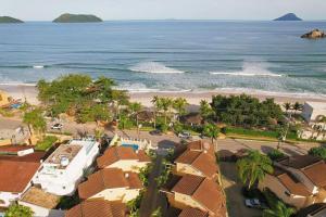 an aerial view of a beach with houses and the ocean at Home 80 I Casa em condomínio pé na areia em Juquehy WIFI e Piscina in São Sebastião