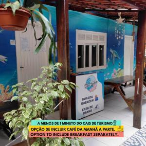 a building with a aquarium with a plant in front of it at Hostel e Pousada Blue Lagoon in Abraão