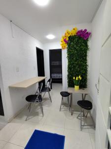 a room with chairs and a table with flowers on the wall at Brisas de la Rivera Yopal in Yopal +4 photos