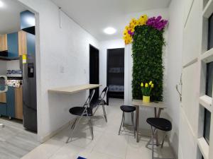 a kitchen with a table and chairs and flowers on a wall at Brisas de la Rivera Yopal in Yopal