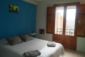 a bedroom with a large bed and a large window at Casa para escaladores o relax, in Bisbal de Falset