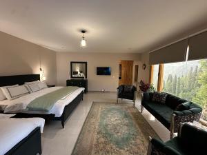 a bedroom with a bed and a couch and a tv at Gali's Home in Abbottābād
