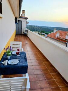 a balcony with a table with a glass of wine at El ático de María in Ruidera