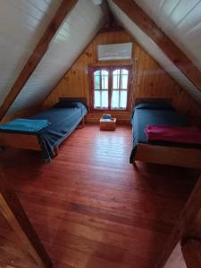 a attic room with two beds and a window at Posada de los Gansos in Baradero +16 photos