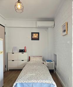 a bedroom with a bed and a white wall at Acropolis View Sky Suite with Jacuzzi near Metro in Athens