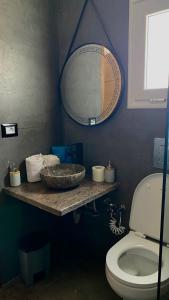 a bathroom with a sink and a mirror and a toilet at Dar Lebharr Kélibia in Kelibia