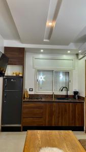a kitchen with a black refrigerator and a window at Dar Lebharr Kélibia in Kelibia