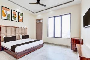 a bedroom with a bed and a large window at Hotel O BAL GOPAL in Delhi