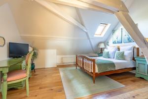 a bedroom with a bed and a desk and a tv at Logement,Environnement Très Paisibles,10 Voyageurs in Cires-lès-Mello +86 photos