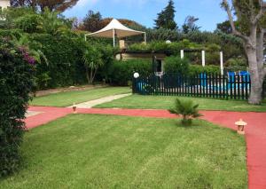 a garden with a fence and a playground at Villa Eleanto in Cefalù