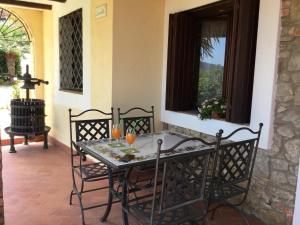 a table and chairs on a patio with a window at Villa Eleanto in Cefalù