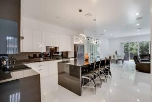 a kitchen with white cabinets and a table and chairs at Modern 3BED 2BATH House in Fort Lauderdale in Fort Lauderdale
