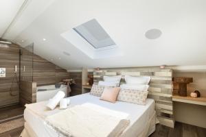 a bedroom with a large bed and a skylight at Étoile Opéra Calme Balnéo AC in Lyon