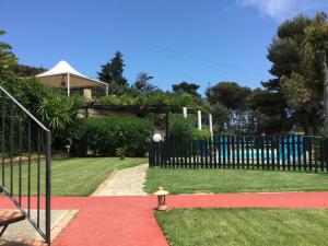 a yard with a fence and a red carpet at Villa Eleanto in Cefalù