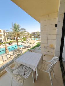 a balcony with a table and chairs and a pool at G-cribs studio pool view in Hurghada