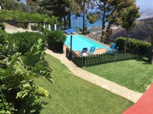 a swimming pool in a yard with a fence at Villa Eleanto in Cefalù