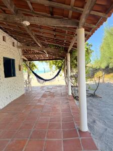 a covered porch with a hammock on the beach at Mirante 180 - Praia de Barreiras in Icapuí