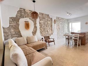 ein Wohnzimmer mit einer Couch und einer Steinwand in der Unterkunft Luxus Haus direkt am Meer bei Novigrad in Dajla + 54 Fotos