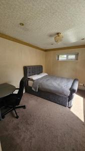 a bedroom with a bed and a desk and a chair at Studio Flat - 5 mins from Manchester Airport in Baguley