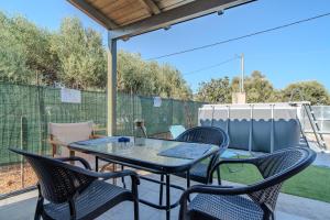 a table and chairs on a patio with a fence at Cretan Blue Bungalow Chania in Chania