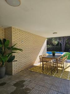 a patio with a table and chairs and a brick wall at Chez Marie in La Muela