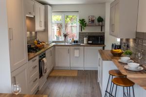 a kitchen with white cabinets and a wooden floor at Birmingham Central Cosy 4BR Home with Free Parking in Birmingham