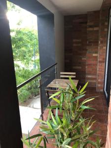 a porch with a wooden table and a plant at Castellum Apartmanház in Gyula