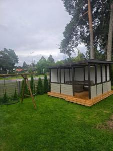 a small house in a park with a swing at Paralepa Guest House in Haapsalu