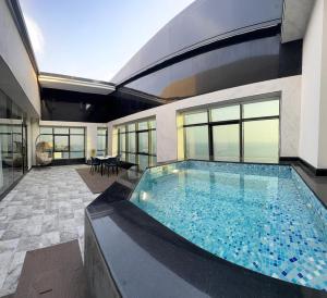 a house with a large swimming pool in the middle at فندق سي تاور in Umm Lajj