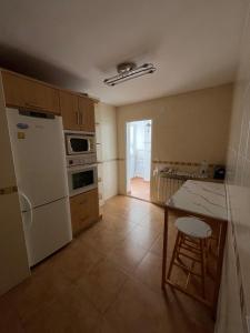 a kitchen with a white refrigerator and a table at La casita de carmen in Cazorla