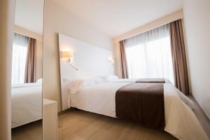 a hotel room with a bed and a mirror at Apartaments Peronel.la in Lleida