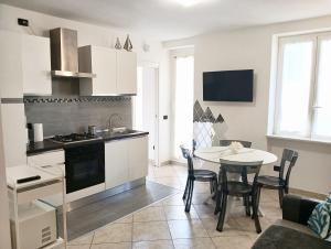 a kitchen and dining room with a table and chairs at L'alcova del Mare in Alassio
