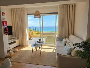 a living room with a couch and a view of the ocean at The Beach House in Porto Santo