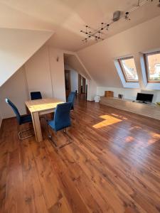 an attic living room with a wooden table and chairs at Séd Völgye Apartman in Veszprém