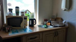 a microwave sitting on top of a kitchen counter at Ezermāja in Ozolnieki